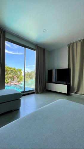a living room with a tv and a large window at Paradise Flower in Wok Tum
