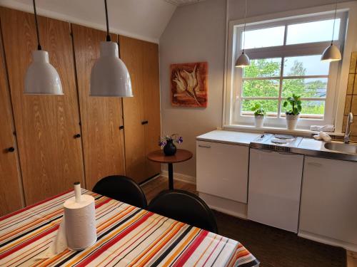 une cuisine avec des placards blancs et une table avec des chaises dans l'établissement City Breakaway, à Sønderborg