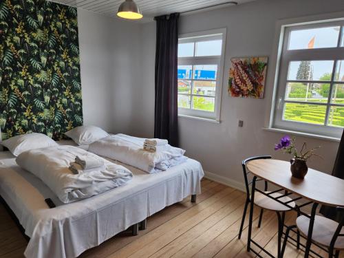 a bedroom with a bed and a table and windows at City Breakaway in Sønderborg