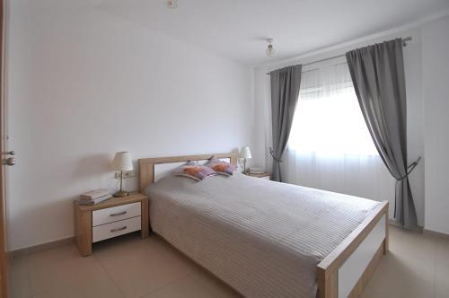 Un dormitorio con una cama grande y una ventana en Santa Clotilde, en Lloret de Mar