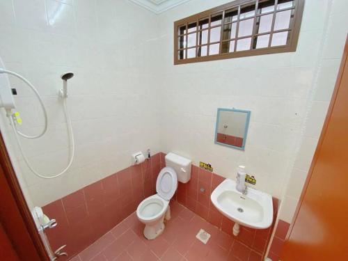 a bathroom with a toilet and a sink at C01 HomeStay in Rinting Village in Masai