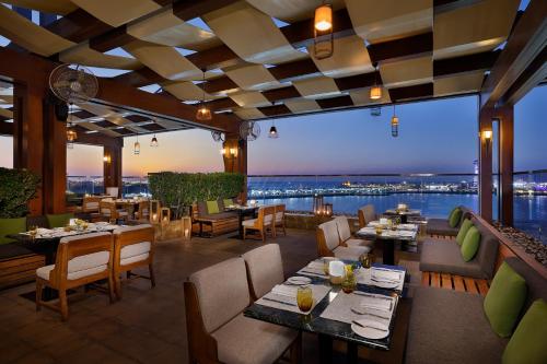 un ristorante con tavoli e sedie e vista di The St. Regis Abu Dhabi a Abu Dhabi