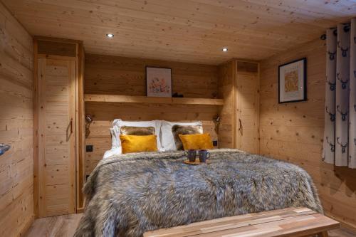 een slaapkamer met een bed in een blokhut bij Chalet Champ de la Lune in Les Gets