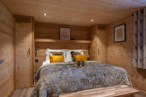 une chambre avec un lit dans une cabane en rondins dans l'établissement Chalet Champ de la Lune, aux Gets