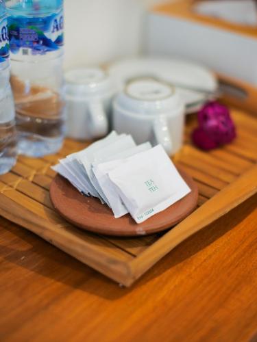 a wooden table with a plate with papers on it at Cactus Guest House Borobudur in Borobudur