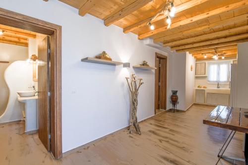 a large room with a white wall and wooden ceilings at Bonzoe #4 in Parikia