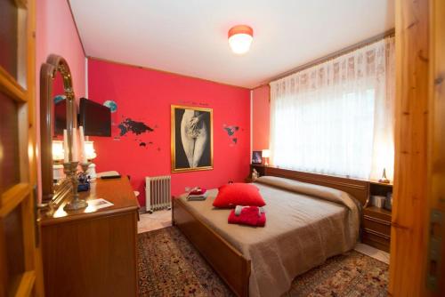 1 dormitorio con paredes rojas y 1 cama con almohadas rojas en 2 bedrooms appartement with shared pool enclosed garden and wifi at Villa nabian, en Challand Saint Victor
