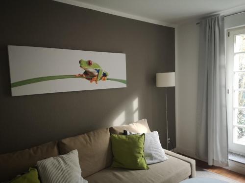 a living room with a couch and a picture of a frog at Appartement Cécile in Potsdam