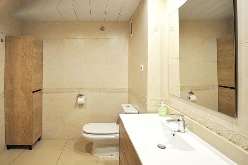 a bathroom with a toilet and a sink and a mirror at Santa Clotilde in Lloret de Mar