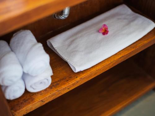 a shelf with towels and a flower on it at Cactus Guest House Borobudur in Borobudur