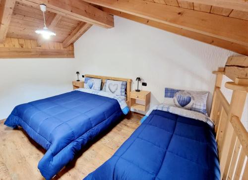 a bedroom with two beds in a room with wooden ceilings at Appartamento Adamello 14 in Pinzolo