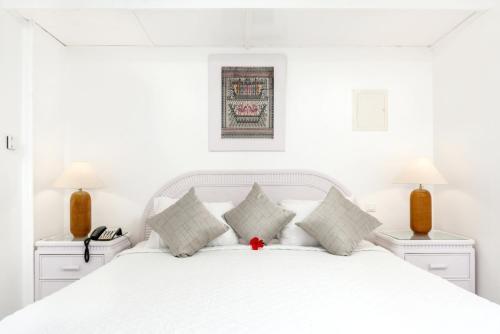 a white bedroom with a white bed with white pillows at Modern studio with swimming pool in Lowlands - 68 m² in Lowlands