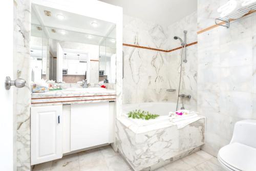 a white bathroom with a tub and a sink at Modern studio with swimming pool in Lowlands - 68 m² in Lowlands