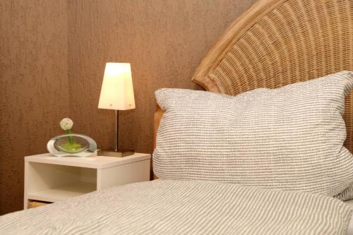 łóżko z poduszką i lampką na nocnym stoliku w obiekcie Ferienwohnung Vogler w mieście Herscheid