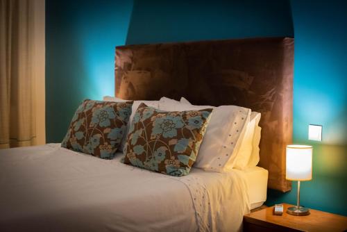 a bedroom with a bed with pillows and a blue wall at 1 Bed Boutique-style Apartment in São Martinho do Porto