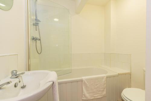 a white bathroom with a tub and a sink at Cherry Property - Grapefruit Suite in Blackpool