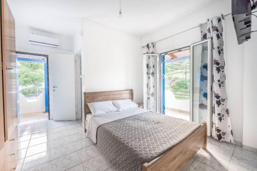 a bedroom with a bed and two windows at Amazing View in Akhladherí