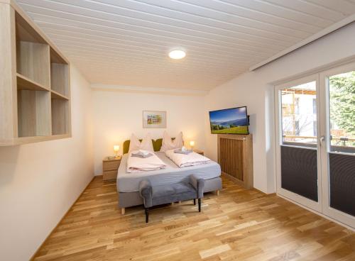 ein Schlafzimmer mit einem Bett und einem großen Fenster in der Unterkunft Arabella Seeappartements in Zell am See