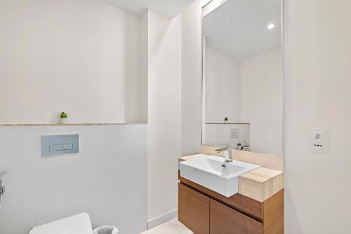 a white bathroom with a sink and a mirror at WelHome - Luxury Living in Dubai's City Walk Building 5 in Dubai