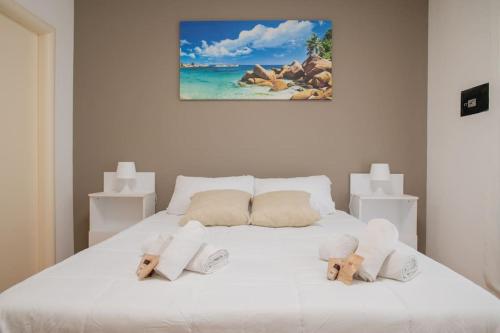 un letto bianco con due orsacchiotti sopra di Adriatico Home[Mare-Fiera-Centro] a Bari