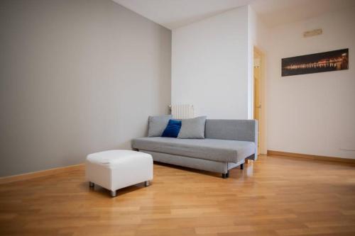 un soggiorno con divano e sgabello di Adriatico Home[Mare-Fiera-Centro] a Bari