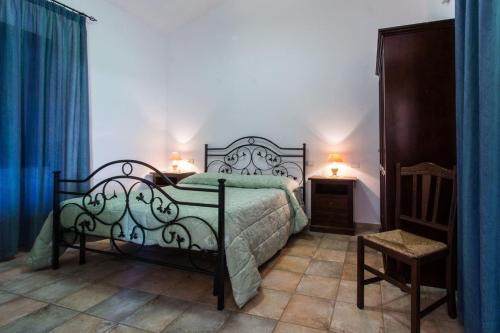 a bedroom with a bed and two tables and a chair at Agriturismo Villa Gaia in Càbras