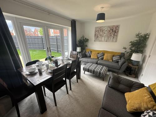 a living room with a table and a couch at 3 Bed Home for Contractors & Relocators with Parking, Garden & WiFi 5 mins walk to Town Centre & Train Station in Stafford
