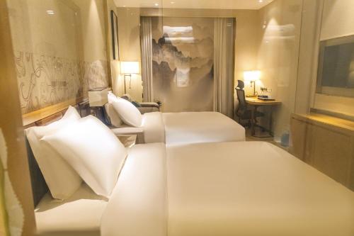 a hotel room with two beds and a desk at The Venetian Hotel in Lusaka