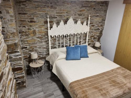 a bedroom with a bed and a stone wall at Casa da Alta in Coja