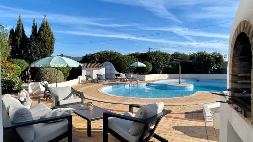 a patio with a pool with chairs and a table at Nicola by Check-in Portugal in Albufeira