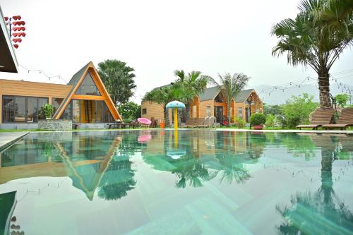 a swimming pool in front of a house at Hoàng Yến Garden Ba Vì in Hanoi