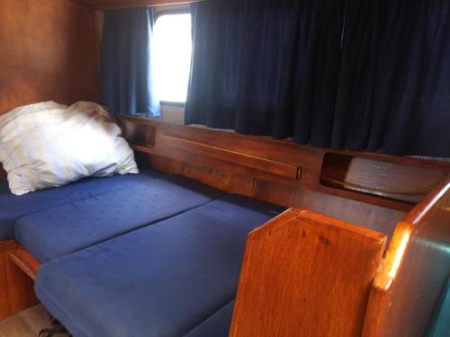 a bed in a small room with a window at Ubytování na námořní jachtě in Veselí nad Moravou