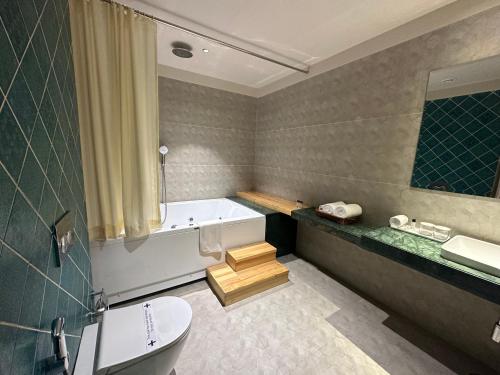 y baño con bañera, aseo y lavamanos. en Hotel Bawa Udaipur, en Udaipur