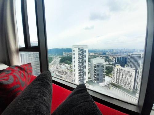 Cette chambre dispose d'un canapé rouge et d'une grande fenêtre. dans l'établissement Netflix Largest Studio @ Empire Damansara, à Petaling Jaya