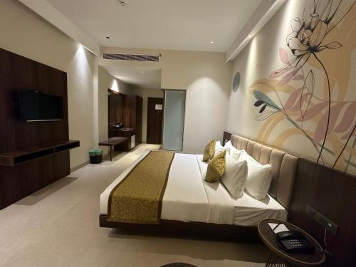 a hotel room with a bed and a television at Hotel Bawa Udaipur in Udaipur