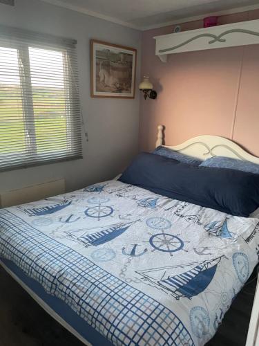a bed with a blue and white quilt on it at Farm stay property Pets and families welcome in Rossnowlagh
