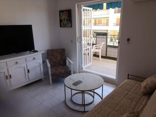 sala de estar con sofá, TV y mesa en Suiza -Apartamento Viñamar en La Mata, en La Mata