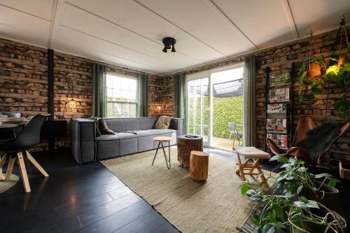 a living room with a couch and a brick wall at 40, Theme Forest world - Dogs allowed! in Oisterwijk