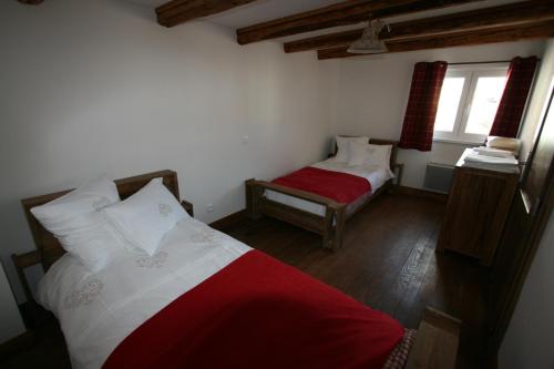 a bedroom with two beds and a red blanket at Les Authentics - Le Domaine d'Autrefois & Spa in Bolsenheim
