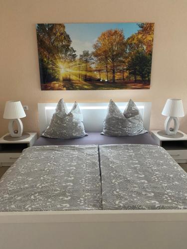 um quarto com uma cama com almofadas e um quadro na parede em Wohnen mitten in Oberhausen, Nähe Centro em Oberhausen