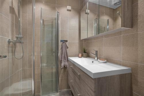 a bathroom with a sink and a shower at Big central apartment w/ a view and parking in Bergen