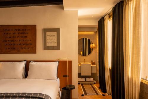 a bedroom with a bed and a mirror at The Venice Venice Hotel in Venice