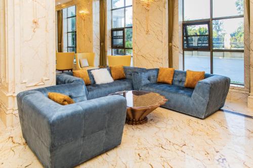 a living room with a blue couch and a table at The Venetian Hotel in Lusaka