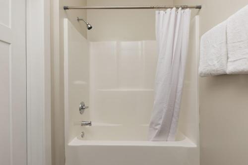 a bathroom with a shower with a white shower curtain at CozySuites Music Row Spacious 2BR with free parking 55 in Nashville