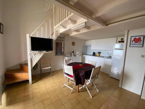 une cuisine et une salle à manger avec une table et des chaises dans l'établissement Appartement en bord de mer avec mezzanine, balcon et parking privé à Port Leucate, 6 couchages - FR-1-81-482, à Port-Leucate