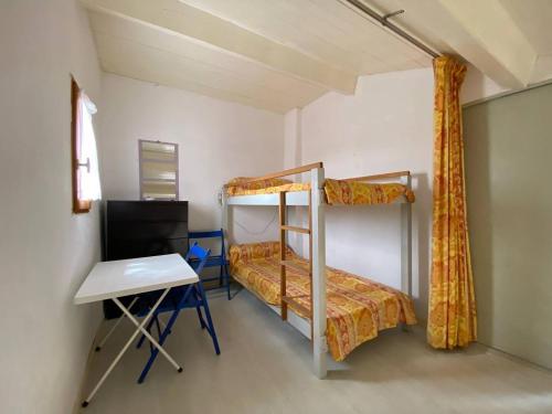 une chambre avec deux lits superposés et un bureau dans l'établissement Appartement en bord de mer avec mezzanine, balcon et parking privé à Port Leucate, 6 couchages - FR-1-81-482, à Port-Leucate