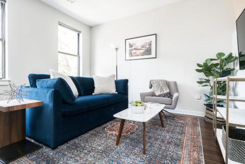 a living room with a blue couch and a table at CozySuites MusicRow Astonishing Studio with free parking 37 in Nashville