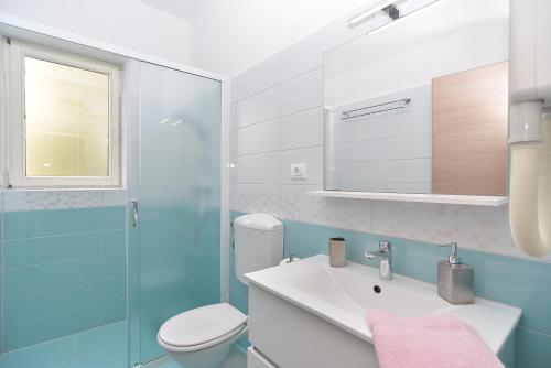 łazienka z umywalką, toaletą i lustrem w obiekcie Apartments Mira 1293 w Fažanie