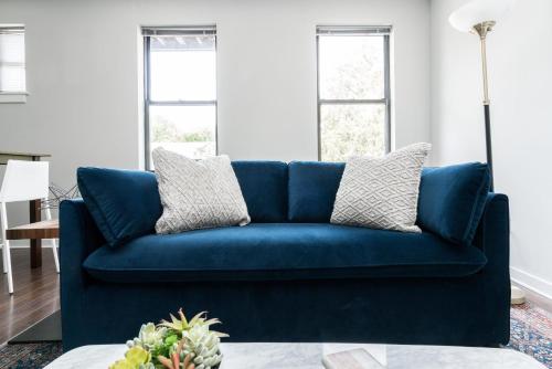 a blue couch in a living room with windows at CozySuites MusicRow Astonishing Studio with free parking 37 in Nashville