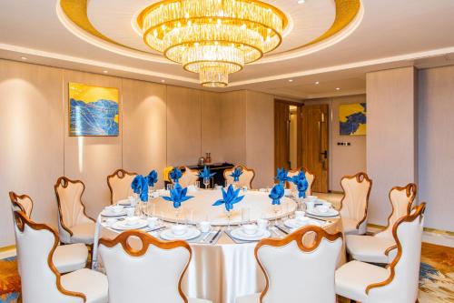 a dining room with a table with a chandelier at The Venetian Hotel in Lusaka